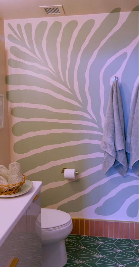 Parete del bagno dipinta con una grande foglia verde salvia